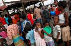 Children queue for food in a camp for people displaced in the aftermath of Cyclone Idai in Beira, Mozambique, March 26, 2019.