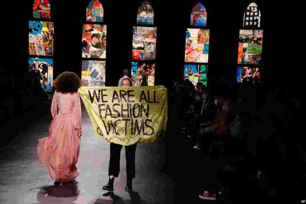 An activist displays a banner during Dior&#39;s Spring-Summer 2021 fashion collection presented during the Paris fashion week in Paris, France.