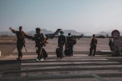 A US Marine escorts US Department of State personnel to be processed for evacuation at Hamid Karzai International Airport, in Kabul, Afghanistan, Aug. 15, 2021. (US Marine Corps photo)