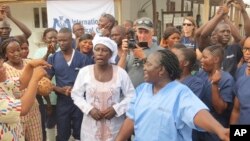 Adama Sankoh (tengah, 40 tahun), meninggalkan pusat perawatan ebola "Mateneh" di pinggiran Freetown, Sierra Leone, Senin (24/8).