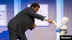 Astrophysicist Neil deGrasse Tyson interacts with Pepper, a social humanoid robot, during the Clinton Global Initiative's annual meeting in New York, Sept. 28, 2015. 