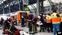 Pasajeros heridos son atendidos en la plataforma de una estación de tren en Barcelona, España, el viernes, 28 de julio de 2017.