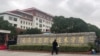 A man lays a bouquet of flowers at an entrance to the Wuxi Vocational College of Arts and Technology following a knife attack, in Wuxi, Jiangsu province, China, Nov. 17, 2024. 