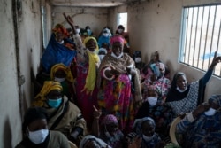 Siny Gueye, center left, is joined by other women fish processors to sing a blessing and thankful song at Bargny beach, Senegal, Apr. 1, 2021.