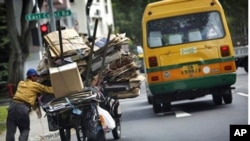 An unemployed man collects cardboard waste to exchange for money along a residential area in Singapore 5 Jan 2011