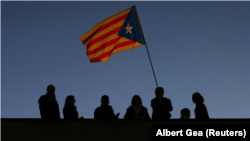 En la imagen de archivo, un hombre porta una estelada en la azotea de un edificio en Barcelona durante una manifestación para la liberación de líderes soberanistas y miembros cesados del Govern, el 11 de noviembre de 2017. 