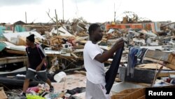 A man hangs his clothes after washing them at the Mudd neighborhood, devastated after Hurricane Dorian hit the Abaco Islands in Marsh Harbor, Bahamas, Sept. 6, 2019. 