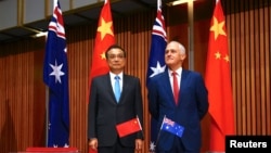 FILE - Australia's Prime Minister Malcolm Turnbull stands with Chinese Premier Li Keqiang before the start of an official signing ceremony at Parliament House in Canberra, Australia, March 24, 2017. 