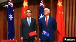 Australia's Prime Minister Malcolm Turnbull stands with Chinese Premier Li Keqiang before the start of an official signing ceremony at Parliament House in Canberra, Australia, March 24, 2017. 