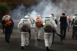 Firefighters disinfect a square against the coronavirus, in western Tehran, Iran, March 13, 2020.