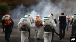 Firefighters disinfect a square against the coronavirus, in western Tehran, Iran, March 13, 2020. 
