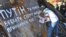 The girl is painting a slogan that reads "Putin you can kill us but you can't take away our freedom" in Kyiv's Independence Square, Ukraine, Mar. 8, 2014. (Jamie Dettmer/VOA)