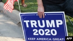 A supporter of US President Donald Trump holds a sign to show their support before the vice presidential debate outside Kingsbury Hall at the University of Utah on October 7, 2020, in Salt Lake City, Utah. (Photo by GEORGE FREY / AFP)