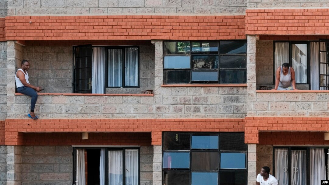 People spend time on their balconies talking to each other at a government-designated quarantine facility in Nairobi, April 6, 2020.