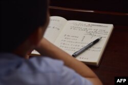 This photo taken on June 26, 2019, shows an adult student taking notes on Xi Jinping taught in a class at the Party School of the Chinese Communist Party's Central Committee for foreign journalists in Beijing.