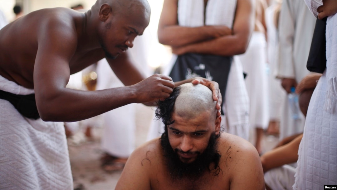 A Muslim pilgrim has his head shaved after casting pebbles at a pillar that symbolizes Satan during the annual hajj pilgrimage, on the first day of Eid al-Adha in Mina, near the holy city of Mecca, Oct. 15, 2013. 