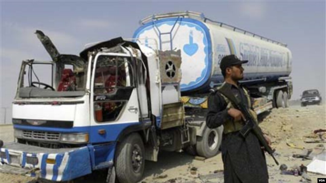 Pasukan keamanan Pakistan menjaga truk tangki bahan bakar NATO setelah terjadinya serangan oleh militan bersenjata.