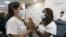 Nurse Annabelle Jimenez, left, congratulates nurse Sandra Lindsay after she is inoculated with the Pfizer-BioNTech COVID-19 vaccine, Monday, Dec. 14, 2020, at the Jewish Medical Center, in the Queens borough of New York. (AP Photo/Mark Lennihan, Pool)