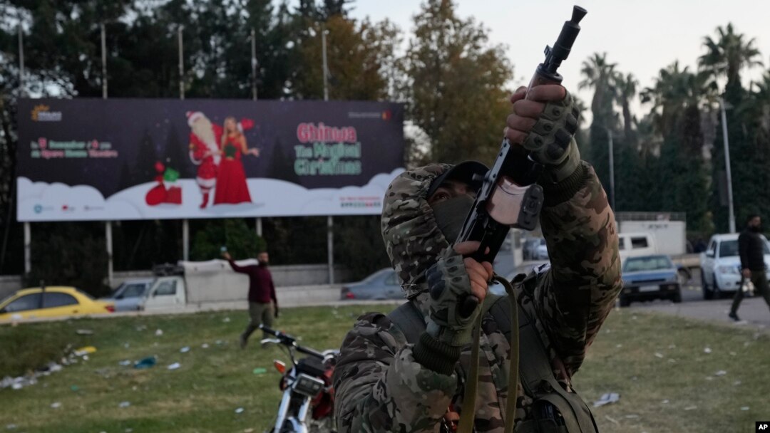 Pripadnik sirijskih opozicionih snaga puca u vazduh tokom proslave pada Asadovog režima u Damasku (Foto: AP/Hussein Malla)