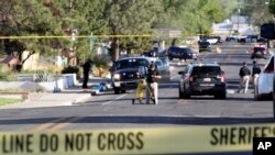Investigators work along a residential street following a deadly shooting Monday, May 15, 2023, in Farmington, New Mexico. 