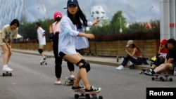 Chen Yanni, 29, a member of Beijing Girls Surfskating Community, rides on a skateboard during a free weekly training session, outside the National Aquatics Centre, or Water Cube, in Beijing, China June 18, 2022. REUTERS/Tingshu Wang