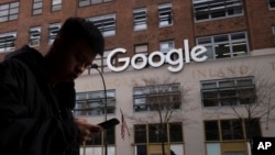 A man using a mobile phone walks past Google offices in New York, Dec. 17, 2018. 