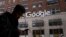 A man using a mobile phone walks past Google offices in New York, Dec. 17, 2018. 