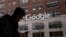 FILE - A man using a mobile phone walks past Google offices in New York, Dec. 17, 2018.