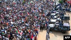 People rally before security forces' vehicles at a mass demonstration near the presidential palace in Sudan's capital, Khartoum, Sept. 12, 2019.