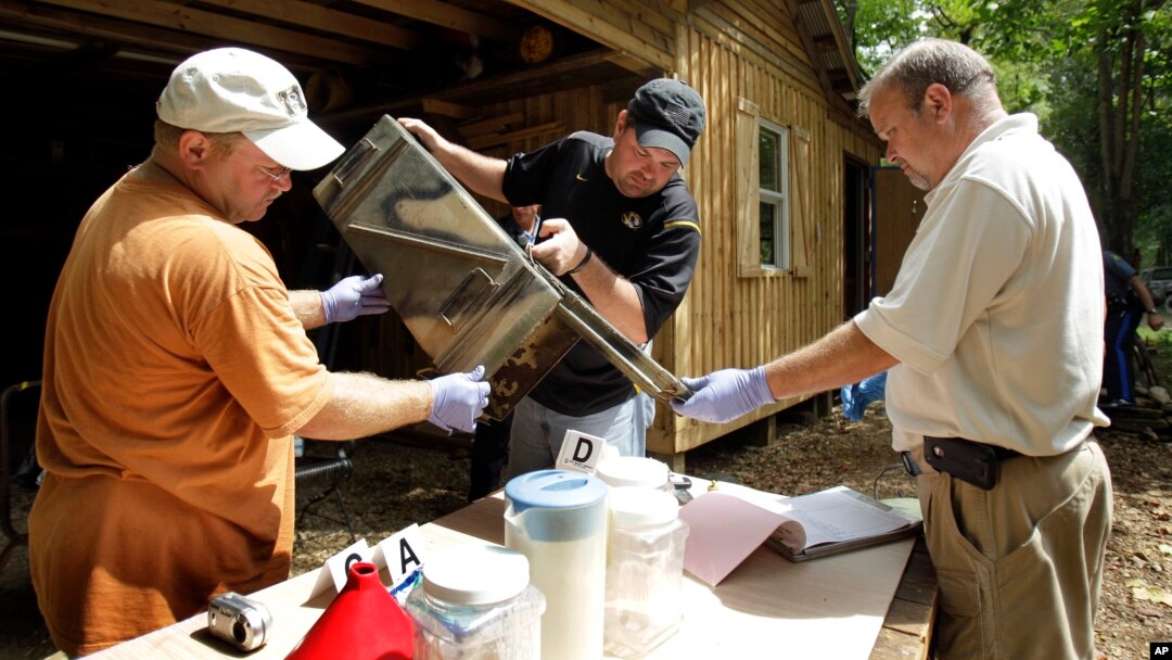 FILE - In this Sept. 2, 2010 photo, authorities in Missouri sort through evidence during a raid of a suspected meth house. 