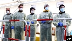 Medical employees wait to carry out tests at a coronavirus test center for public service employees, in Munich, Germany, March 23, 2020.