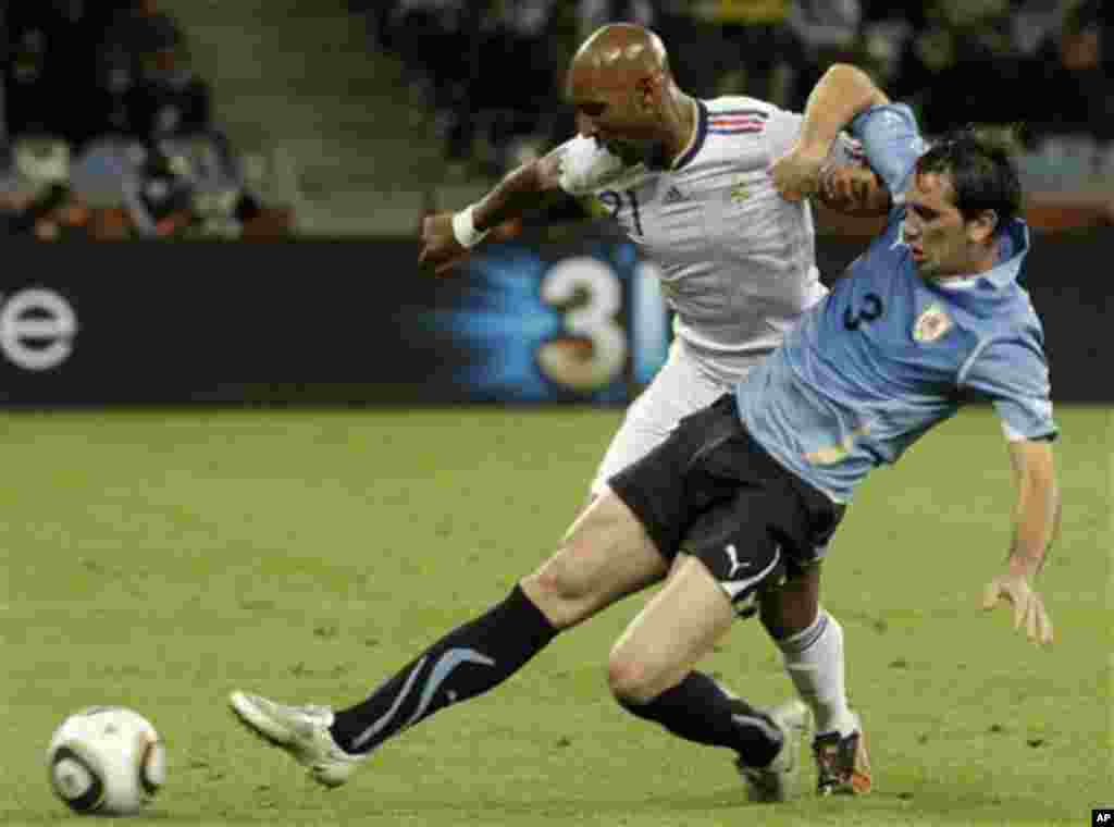 Uruguay's Diego Godin, right, is tackled by France's Nicolas Anelka, left, during the World Cup group A soccer match between Uruguay and France in Cape Town, South Africa, on Friday, June 11, 2010. (AP Photo/Schalk van Zuydam)