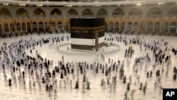 FILE - Muslim pilgrims circumambulate the Kaaba, the cubic building at the Grand Mosque, as they wear masks and keep social distancing, a day before the annual hajj pilgrimage in Mecca, Saudi Arabia, July 17, 2021.