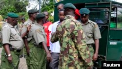 FILE - Four men charged with helping al Qaida-linked militants launch an attack on the Westgate mall, arrive under guard from prison warders during a court session in Nairobi.