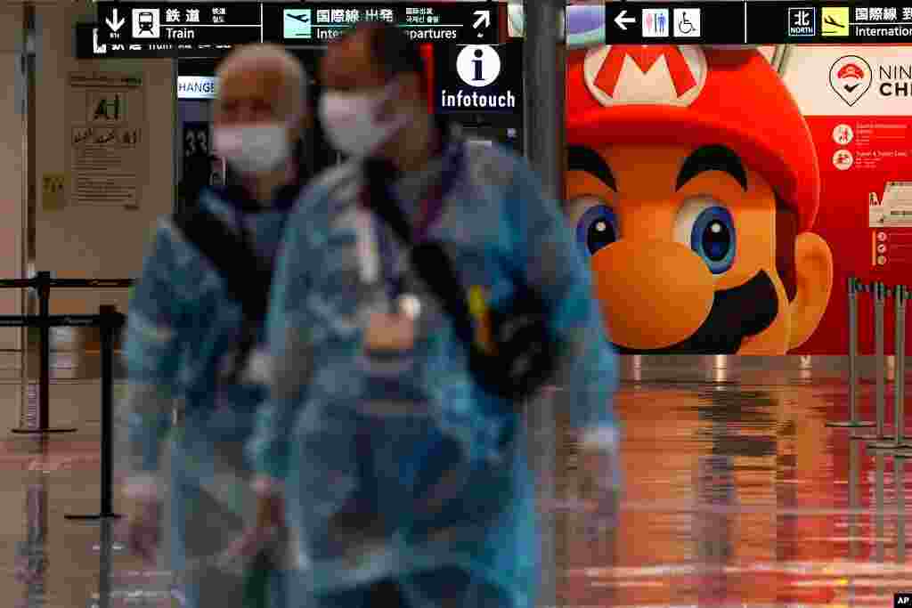 Medical personnel walk by as they wait for the arrival of international passengers at Narita International Airport, in Narita, east of Tokyo.