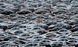 FILE - A worker walks along rows of Mercedes-Benz cars at a shipping terminal in the harbor of the town of Bremerhaven, Germany, March 8, 2012.