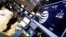 A trader walks by the post that handles AT&T on the floor of the New York Stock Exchange, March 6, 2015.
