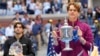 Jannik Sinner, of Italy, holds the championship trophy as Taylor Fritz, of the United States, looks on after Sinner won the men's singles final of the U.S. Open tennis championships, in New York, Sept. 8, 2024. 