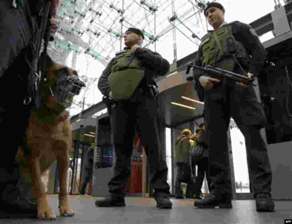 Police dog Kira and two police officers wearing bulletproof vests stand guard at the main train station in Berlin, Germany, Wednesday, Nov. 17, 2010. Germany's interior minister announced Wednesday that he is ordering increased security in the country in 