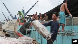 Workers unload frozen fish from a Thai fishing boat in Ambon, Indonesia.