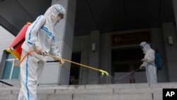 Staff of the Pyongyang Primary School No. 4 spray disinfectant in Pyongyang, North Korea, June 30, 2021, as Kim Jong berated top officials for failures in coronavirus prevention that caused a ‘great crisis.’