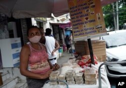 Una comerciante callejera vende queso, frijoles y dulces en Río de Janeiro, Brasil, el viernes 9 de octubre de 2020. Muchos brasileños luchan por sobrevivir en medio de la pandemia de COVID con menos ayuda del gobierno y un alza general de precios.
