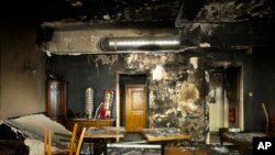 FILE - Tables and chairs stand in the burned out Jewish-run bar 'Morgen wird Besser' (Morning will be better) in Berlin, Germany,Aug. 21, 2020. The Jewish-run bar was destroyed in an arson attack on Aug. 14, 2020.