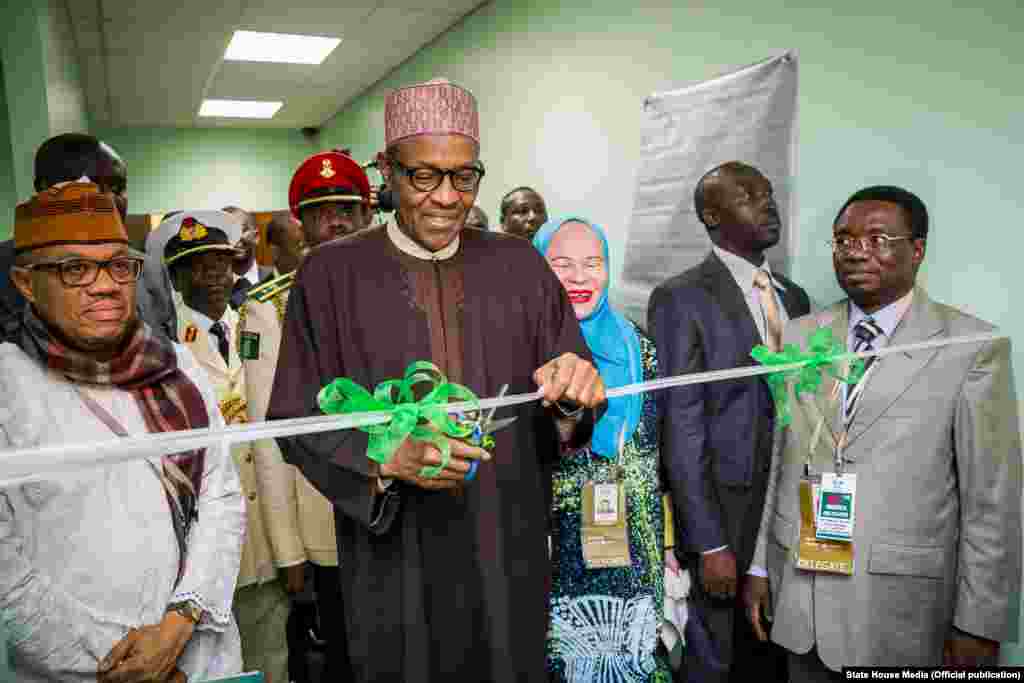 Shugaba Muhammadu Buhari yana bude Cibiyar Ayyukan Shige da Ficen Baki ta Najeriya tare da karamar jakadiya Mrs Uche Ajulu-Okeke da mai rikon mukamin babban jakadan Najeriya a Afirka ta Kudu, Mr. Martins Cobham a lokacin da ya gana da al&#39;ummar Najeriya a karamin ofishin jakadancin Najeriya na Johannesburg a Afirka ta Kudu.