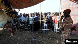 FILE - Sudanese military officers guard Ethiopians who fled war in Tigray region at the Fashaga camp on the Sudan-Ethiopia border, Nov. 20, 2020. 