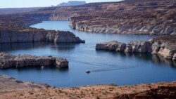 A boat cruises along Lake Powell, July 31, 2021, near Page, Ariz.