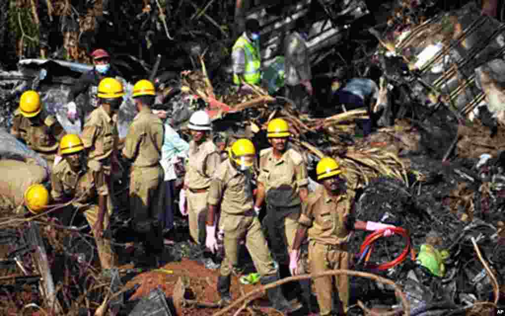 Indian firemen working at the plane crash site of an Air India Express jet that crashed into a forested gorge with the loss of 158 lives in Mangalore, 24 May 2010
