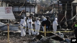 Soldiers and investigators walk through the scorched rubble of the open-air San Pablito fireworks market that exploded in Tultepec on the outskirts of Mexico City, Dec. 21, 2016. The market was especially well stocked for the holidays and bustling with hundreds of shoppers when a powerful chain-reaction explosion ripped through its stalls Tuesday, killing and injuring dozens.