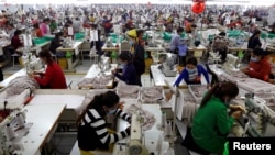 FILE - Employees work at a factory supplier of the H&M brand in Kandal province, Cambodia, Dec. 12, 2018.