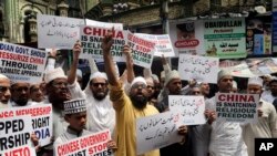 FILE - Indian Muslims shout slogans during a protest against the Chinese government, in Mumbai, India, Sept. 14, 2018. Protesters demanded that China stop detaining ethnic Uighurs in detention and political indoctrination centers in Xinjiang region.